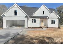 Charming new construction home featuring white siding, a gray roof, and a spacious two car garage at 5037 Faith Rd, Salisbury, NC 28146