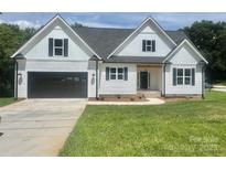 Charming two-story home featuring a black garage door, black framed windows, and a well-manicured lawn at 5037 Faith Rd, Salisbury, NC 28146