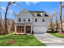 New construction home featuring gray siding, brick accents, an attached garage, and a well-manicured lawn at 3110 Westerwood Dr, Charlotte, NC 28214