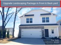 Charming two-story home featuring stone accents, a two-car garage, and manicured landscaping at 8205 Stonemere Ln, Charlotte, NC 28215