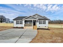 Newly built home with gray siding, a porch, and a concrete driveway at 882 Old Mocksville Rd, Statesville, NC 28625