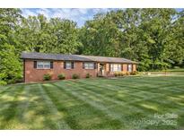 Charming brick home featuring manicured lawn and lush, mature landscaping at 216 Delview Dr, Cherryville, NC 28021