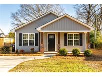 Gray house with a covered porch, brick columns, and black shutters at 267 Elm Nw Ave, Concord, NC 28025