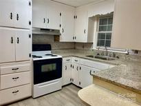 Classic kitchen with white cabinets, granite countertops, and black and white appliances at 2040 Ne 25Th Street Dr, Hickory, NC 28601