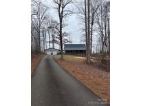 Charming house with a metal roof and a large detached garage, set back on a long private driveway at 122 Breeze Hill Pl, Statesville, NC 28625