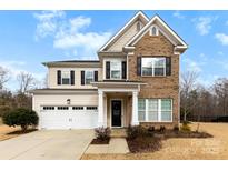 Two-story brick home with a two-car garage and landscaped yard at 1246 Gold Rush Ct, Fort Mill, SC 29708