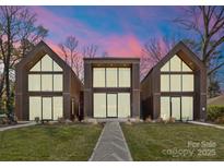 Modern exterior elevation of home featuring expansive windows and unique architectural design with twilight sky at 4026 Chevington Rd # 102, Charlotte, NC 28226