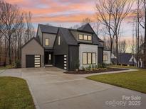 Striking modern home showcasing unique architecture and professional landscaping, including a spacious driveway and manicured lawn at 116 Hunt Camp Trl # 11, Davidson, NC 28036