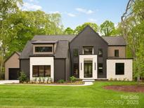 Stunning modern home featuring a black and stone exterior with a well-manicured lawn at 116 Hunt Camp Trl # 11, Davidson, NC 28036