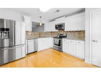 Modern kitchen with stainless steel appliances and white cabinets at 9149 Washam Potts Rd, Cornelius, NC 28031