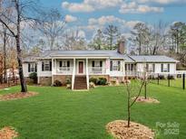 Ranch style home with covered porch, landscaped lawn, and fenced yard at 2430 Lazy Oak Dr, Lancaster, SC 29720