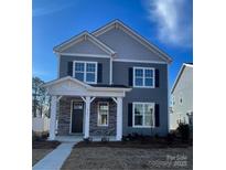 Two-story house with gray siding, stone accents, and a covered porch at 9601 Pointer Rd # 77, Huntersville, NC 28078