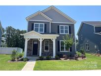 Charming two-story home with stone accents, dark shutters, and a well-manicured front yard at 9601 Pointer Rd # 77, Huntersville, NC 28078