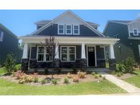 Charming home with a covered front porch, stone accents, and beautiful landscaping at 9605 Pointer Rd # 78, Huntersville, NC 28078