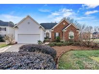 Charming single Gathering home featuring brick and vinyl siding, attached garage, and a beautifully landscaped yard at 10302 Sawtimber Ct, Huntersville, NC 28078