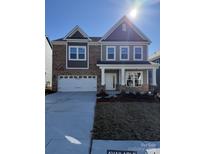 Two-story brick home with gray accents and a three-car garage at 11112 Lochmere Rd, Charlotte, NC 28278