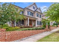 Two-story brick home with landscaping and brick wall at 1117 Churchill Commons Dr, Charlotte, NC 28211