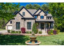 Beautiful stone and stucco home with a manicured front yard and a charming water fountain at 546 Little Cove Ln, Lake Wylie, SC 29710