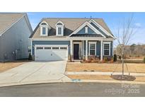 Charming blue single-Gathering home featuring a two-car garage, manicured lawn, and covered front porch at 401 Portrait Way, Indian Trail, NC 28079