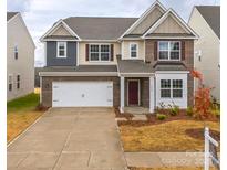 Two story brick home with a three car garage and landscaping at 3064 Virginia Trail Ct, Fort Mill, SC 29715