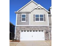 Two-story townhome with gray siding, stone accents, and a two-car garage at 4027 Lawnview Dr, Charlotte, NC 28269