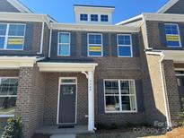 Charming brick townhome with gray shutters and an available sign displayed in the front windows at 5548 Stafford Rd # 29, Charlotte, NC 28215