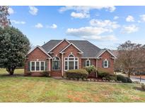 Charming brick home featuring lush landscaping and a welcoming entrance at 4687 Snow Dr, Harrisburg, NC 28075