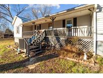 Front porch with wooden swing and steps leading to the front door at 10310 Stokes Ferry Rd, Gold Hill, NC 28071