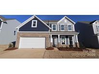 Two-story home with navy blue and gray siding, brick accents, and a white garage door at 2608 Clipper Nw Ct, Concord, NC 28027