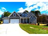 Charming two-story home with a well-manicured lawn and a two-car garage at 143 Dabbling Duck Cir, Mooresville, NC 28117