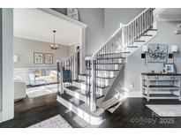 Elegant staircase with dark wood steps, white risers, and decorative wrought iron railings at 2315 Smith Harbour Dr, Denver, NC 28037