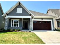 Charming single-story home showcasing a stone-accented facade, attached garage, and manicured front lawn at 2971 Alveston Nw Dr # 29, Concord, NC 28027