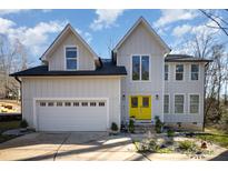 Two-story house with a yellow door, attached garage, and landscaping at 10221 Hanging Moss Trl, Mint Hill, NC 28227