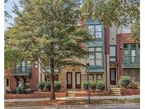 Attractive brick townhome with two-story design, arched entry, and landscaping at 658 E 10Th St, Charlotte, NC 28202