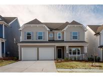 Charming two-story home featuring a covered porch, well-maintained lawn, and a two-car garage at 18024 Wilbanks Dr, Charlotte, NC 28278