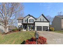 Two-story home with gray and white exterior, two-car garage, and landscaped yard at 1811 Robbins Meadows Dr, Waxhaw, NC 28173