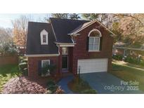 Brick home with two-car garage and landscaped yard at 7031 Walton Heath Ln, Charlotte, NC 28277