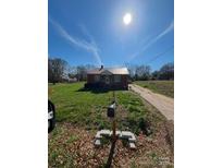 Brick ranch house with a metal roof and a spacious yard at 111 James Love School Rd, Shelby, NC 28152