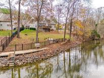 House with deck overlooking a pond, featuring a wooden walkway and a black metal fence at 1345 Shimmer Light Cir, Rock Hill, SC 29732