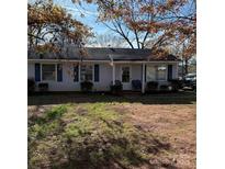 Cozy single-story home with blue shutters and mature trees in a residential neighborhood at 1406 Milan Rd, Charlotte, NC 28216