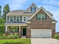 Two-story brick home with a metal roof and landscaped lawn at 17718 Snug Harbor Rd, Charlotte, NC 28278