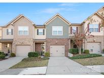 Brick front of charming townhome with two-car garage and landscaping at 236 Ascot Run Way, Fort Mill, SC 29715