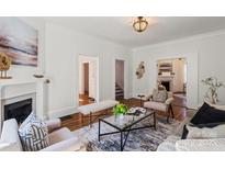 Cozy living room with decorative fireplace, stylish seating, and hardwood floors at 507 W 2Nd Ave, Gastonia, NC 28052