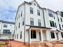 New construction townhome with white siding, black trim, covered front porch and stylish modern architecture at 13013 Moon Rd # 41, Charlotte, NC 28277