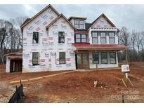 Newly constructed two-story home with red roof and wrap-around porch at 2007 Kendall Dr # 6, Wesley Chapel, NC 28173