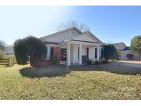 Charming single-story home with a well-manicured lawn and inviting front porch at 3076 Champion Sw Ln, Concord, NC 28025