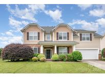Charming two-story home with a stone facade, well-manicured lawn, and attached two-car garage at 11005 Magna Ln, Indian Trail, NC 28079