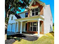Two-story house with brick and siding, covered porch, and attached two-car garage at 18514 Victoria Bay Dr, Cornelius, NC 28031