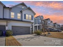 Modern 2-story townhome with gray siding, white accents, and a 2-car garage at 2522 Lola Ave, Charlotte, NC 28205