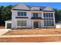 A Modern farmhouse with white siding, black trim and metal roof accents stands out at 1015 Kendall Dr # 4, Wesley Chapel, NC 28173